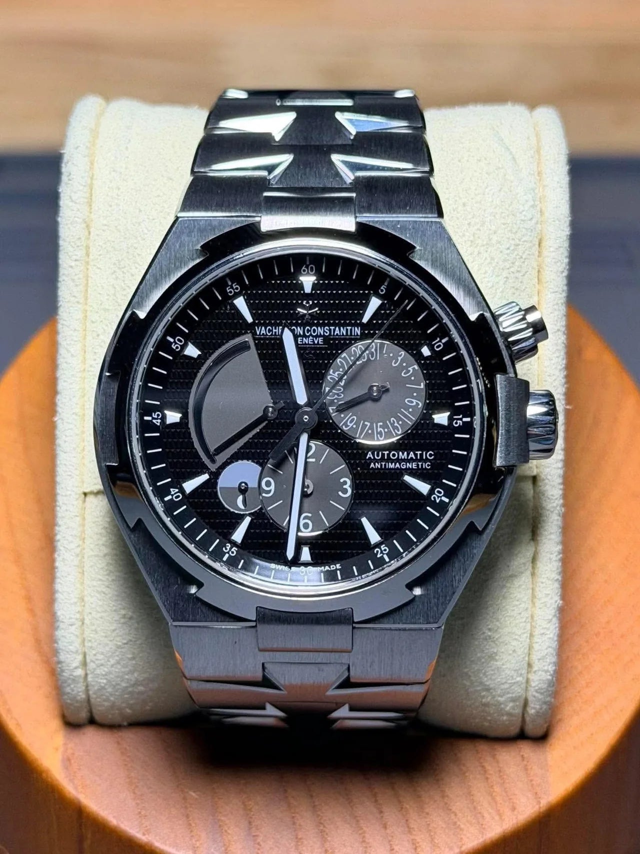 Black chronograph with a dark bracelet on a watch cushion