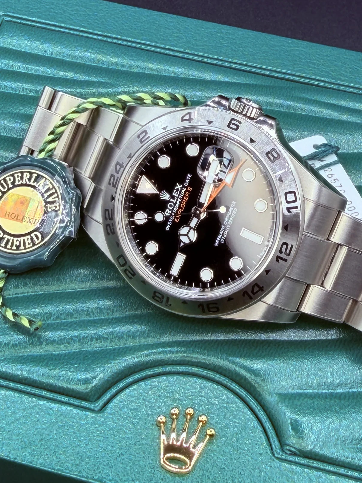 White dial steel watch with an orange hand and numbered bezel