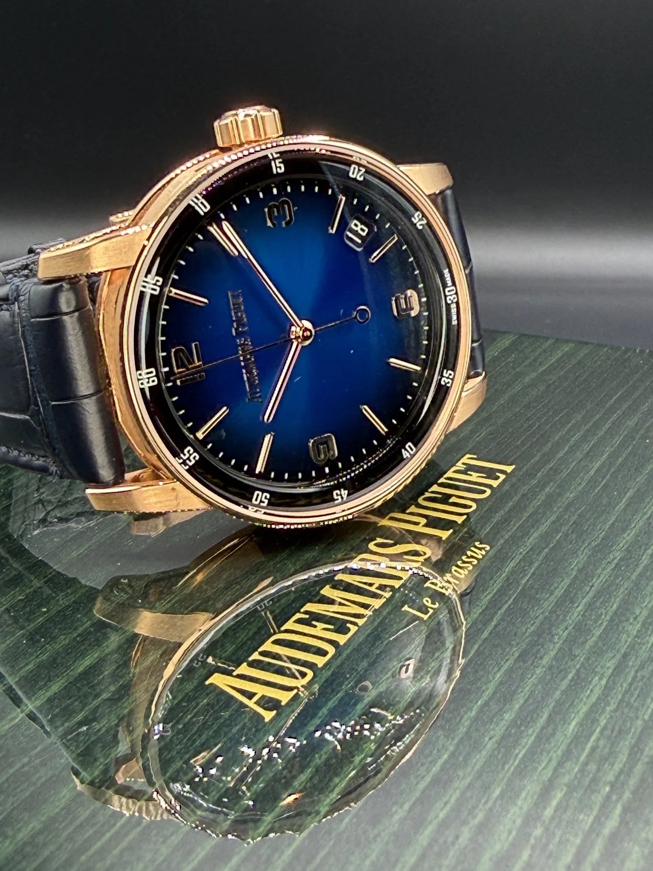Blue dial watch in a gold-tone case with a dark strap