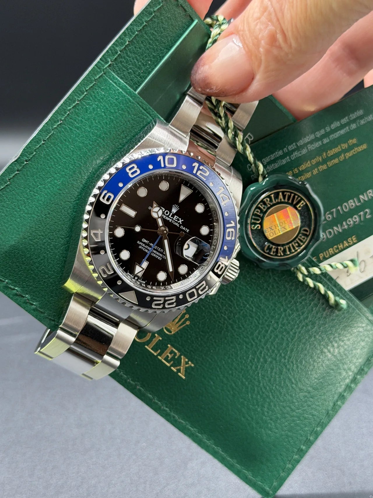 Steel watch with a blue and black bezel on a green strap