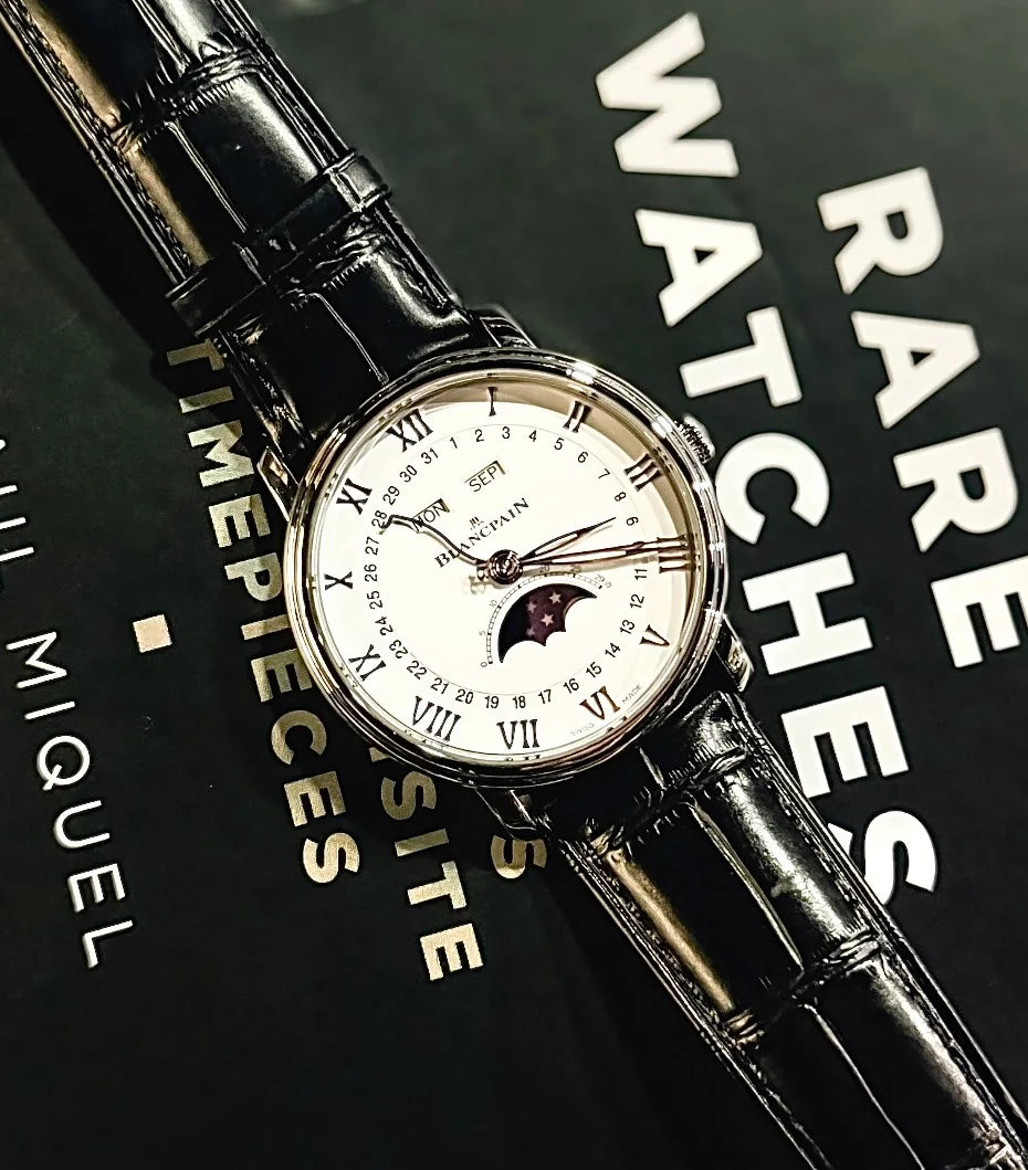 White dial watch with Roman numerals and a black leather strap